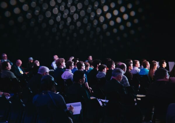 crowd of people sitting on chairs inside room