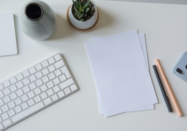 white printer paper beside white apple keyboard