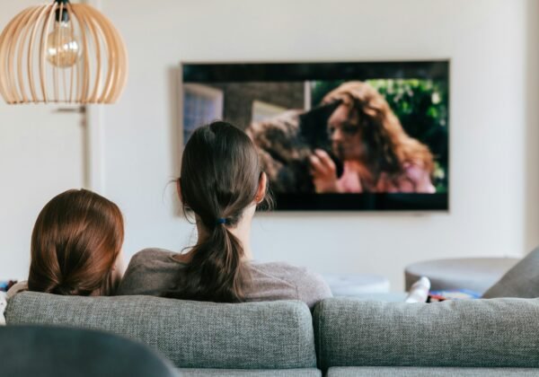 a couple of women sitting on top of a couch
