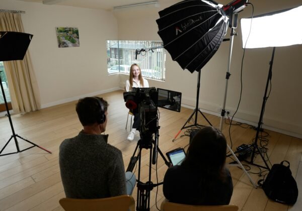 A group of people sitting around a camera